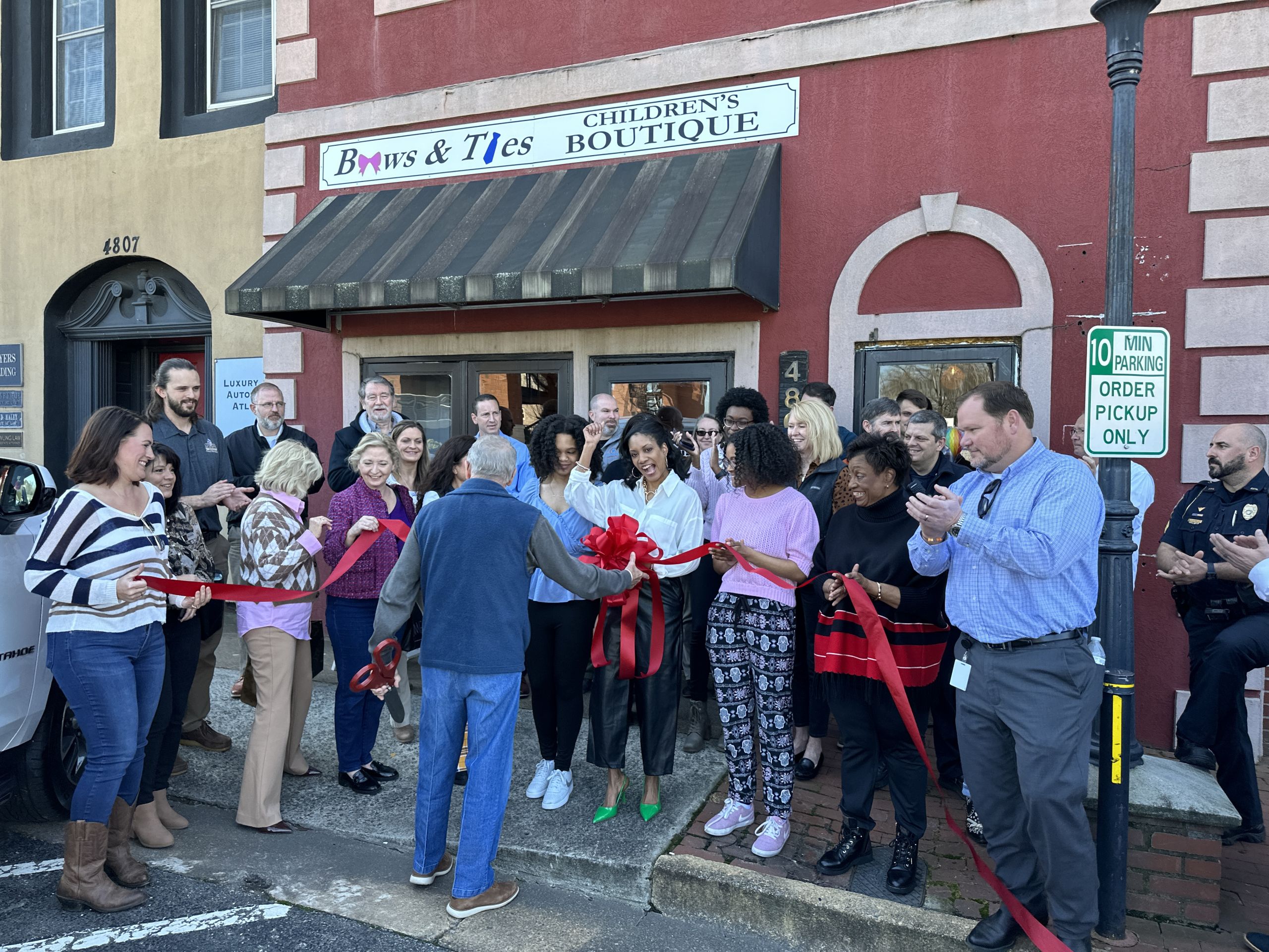 Image Kwanza Zimmerman Celebrating with Mayor Allegood and the City Team at the Ribbon Cutting for Bows and Ties Children's Boutique