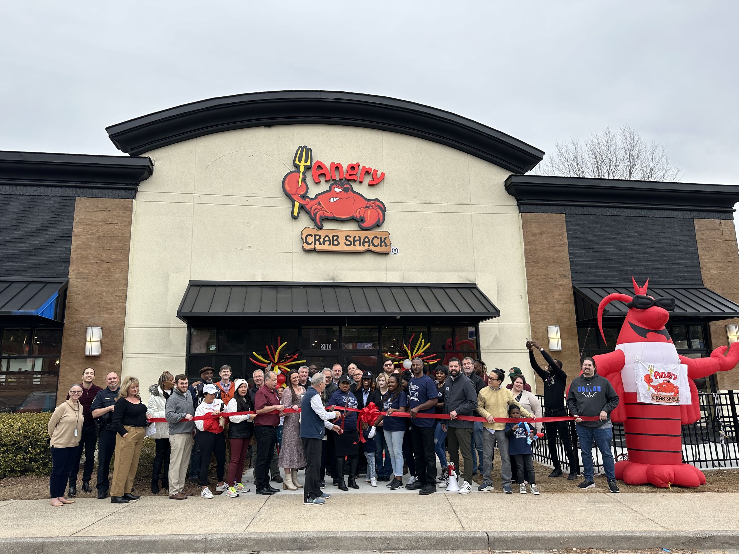 Image Red Ribbon Being Cut with Group of People at Acworth Angry Crab Shack