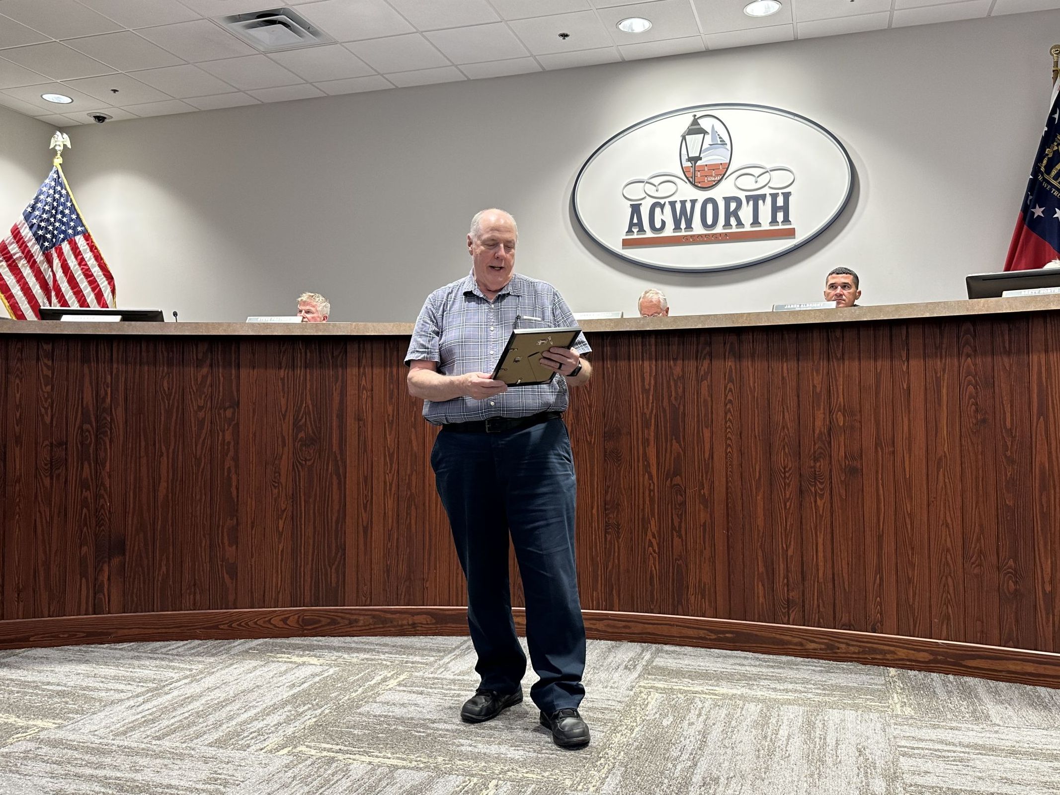 Image Man standing in city council chambers reading a proclamation