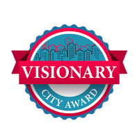 Award badge titled "Visionary City Award," featuring a city skyline in the background with a red ribbon.