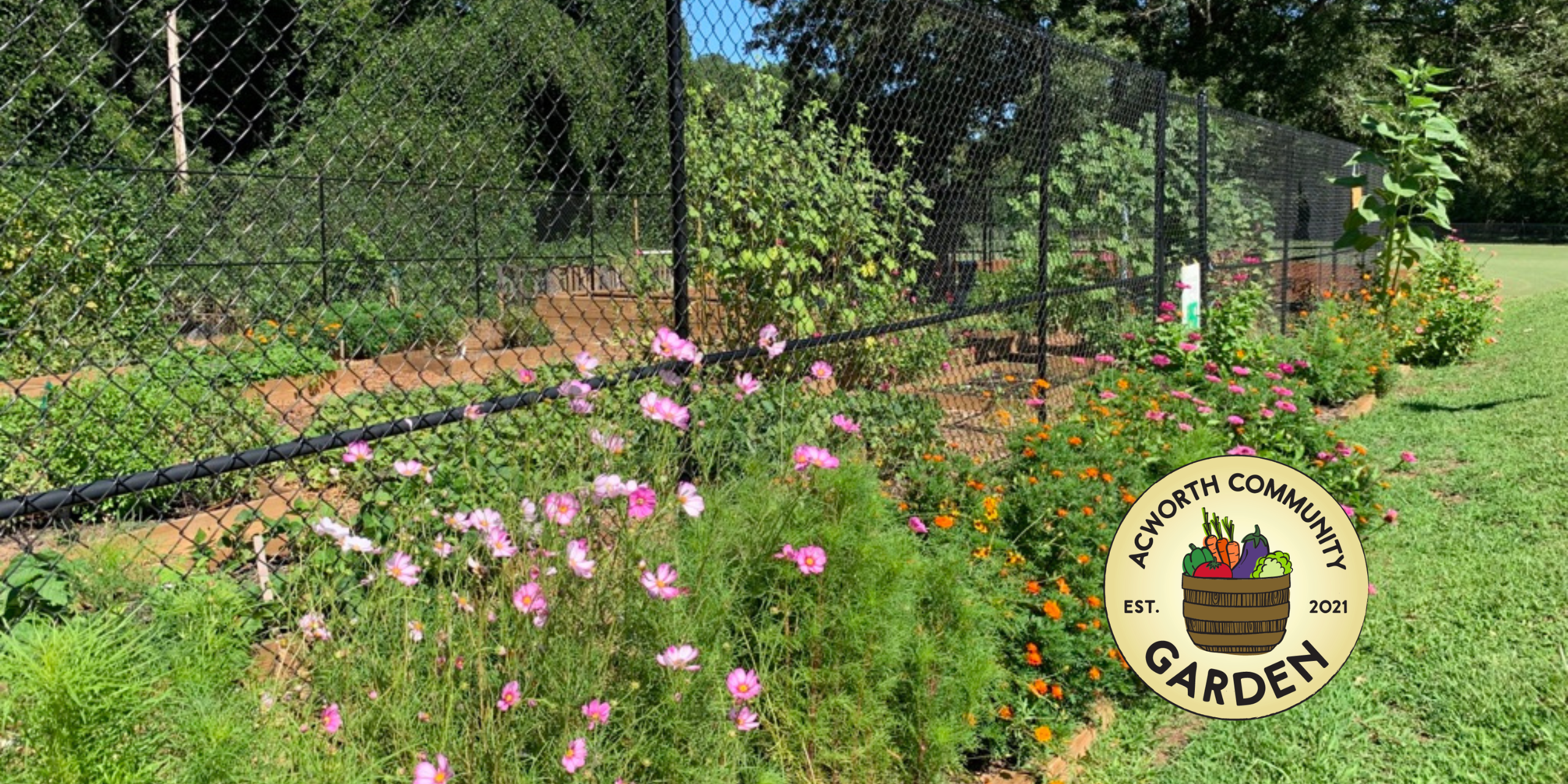 A fenced community garden with blooming flowers in the foreground and various plants inside, reflecting the spirit of growing good; a round “Acworth Community Garden” logo is displayed on the right.